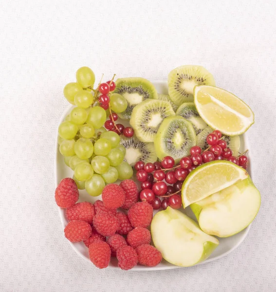 Uvas Framboesas Pedaços Kiwi Frutas Maçãs Limas Prato Branco — Fotografia de Stock