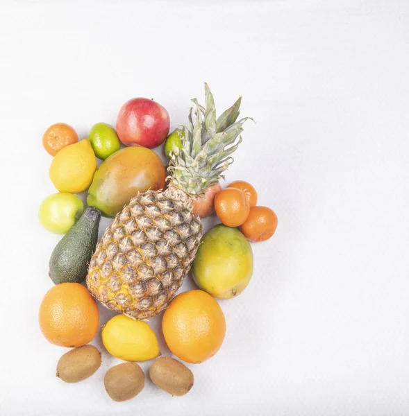 Pineapple with a lot of fruits on the white background closeup