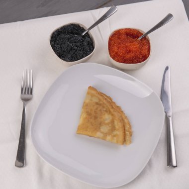 Kaselerde siyah ve kırmızı havyar ile beyaz tabakta Pancake