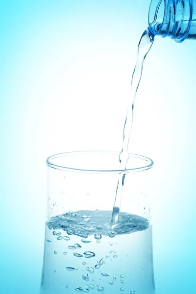 白を背景に瓶からコップに水を入れる — ストック写真