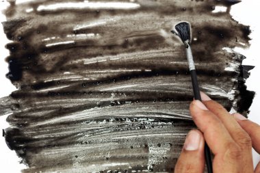 Elini tutarak fırça ve boya renk beyaz kağıt üzerinde siyah