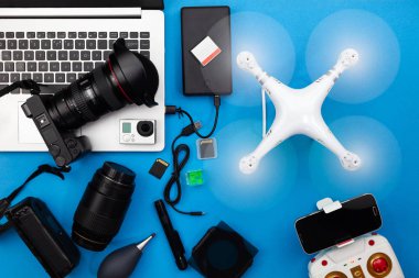 Lensler, uçak ve ekipman mavi Kağıt arka plan üzerinde profesyonel fotoğrafçı ile dijital fotoğraf makinesi