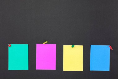 Pimleri ve renkli yapışkan notlar boş yazı tahtası üzerinde itmek.