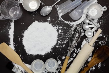 farklı mutfak araçları koyu siyah arka plan üzerine un serpilir. Fırın madde Üstten Görünüm.