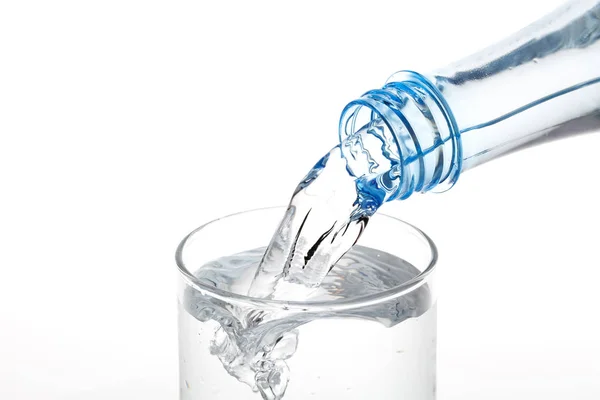 Beyaz arka planda şişeden cama su dökmek