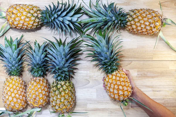 Mano Sosteniendo Piña Con Hilera Frutas Piña Sobre Fondo Mesa — Foto de Stock