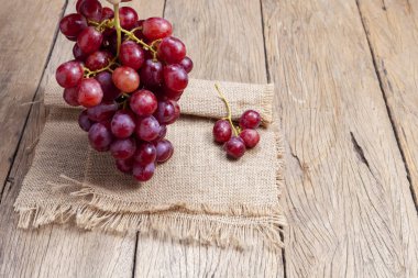 Eski ahşap masa arka plan üzerinde kırmızı üzüm.