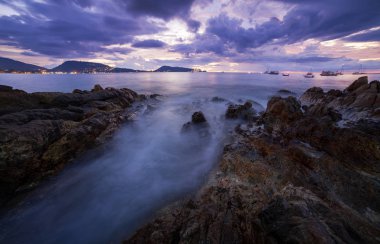 Uzun pozlama görüntü günbatımı manzarası, güzel manzara ve doğa akşam bulutlar ve gökyüzü güzel renklerle ışık kaya ile dramatik gökyüzü deniz manzarası.