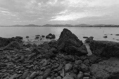 Siyah beyaz kayalarla kaplı uzun deniz manzarası, arka plan ve duvar kağıdı için doğa bileşimi olarak kullanılabilir..