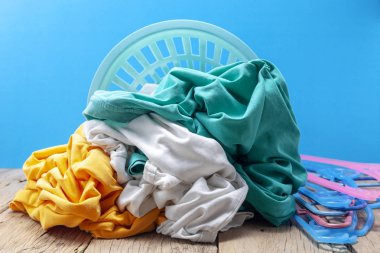 Kirli çamaşır sepetinin içinde ahşap, mavi arka planda. 