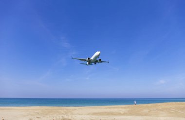 Ticari uçak açılış deniz ve açık mavi gökyüzü güzel sahne doğa arka plan konumda mai khao beach phuket Tayland, Amazing Simgesel Yapı insanlar üzerinde phuket airport adlı bir fotoğraf almak.