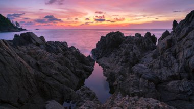 Uzun pozlama görüntü günbatımı kaya ile dramatik gökyüzü deniz manzarası