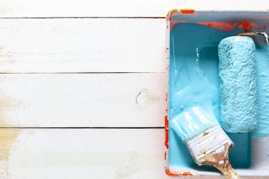 Beyaz ahşap arka plan üzerinde renk tepsisinde boya fırçası