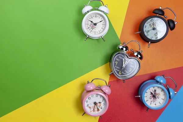 美しい紙の背景にカラフルな目覚まし時計のフラットレイ — ストック写真