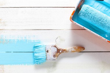 Beyaz ahşap arka plan üzerinde renk tepsisi ile boya fırçası