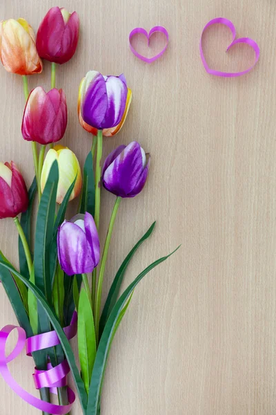 Spring flower of multi color Tulips on wood background