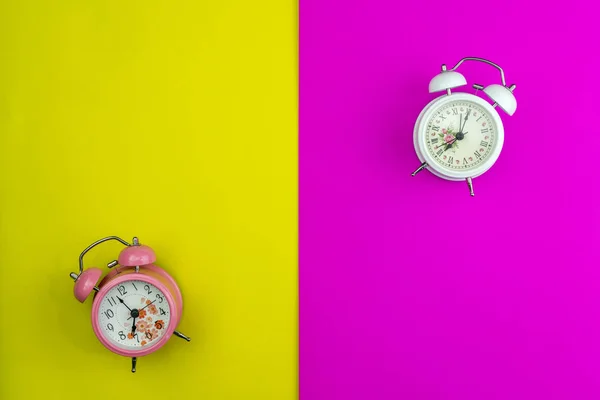 Colocação plana de novo relógio de alarme bonito em papel rosa e amarelo — Fotografia de Stock