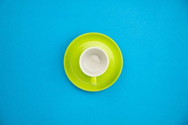 Mavi kağıt arka planda renkli kahve fincanı