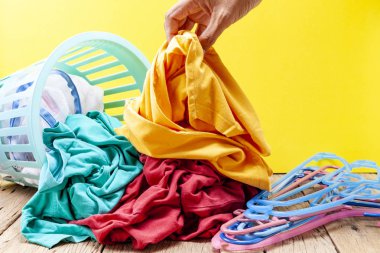 Kirli çamaşır yıkama sepeti ahşap tahta üzerinde içinde tutan el