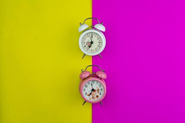 Pembe ve sarı kağıt üzerinde güzel yeni çalar saat Düz yatıyordu 