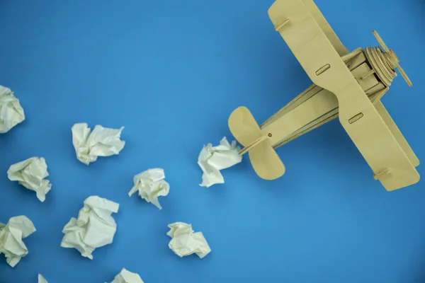Avión de madera con bola de papel en lugar de nubes blancas en azul — Foto de Stock