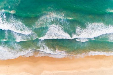Hava manzaralı kumlu sahil ve kumlu sahile çarpan dalgalar yaz mevsiminde güzel tropikal deniz görüntüsü Aerial view drone çekimi, yukarıdan aşağıya yüksek açılı görüntü