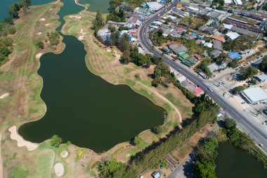Modern evle birlikte asfalt yol ve göl manzaralı hava aracı.