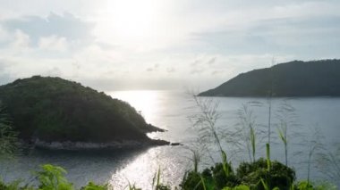 Denizde küçük bir adanın 4k Timelapse 'si Gün batımı ya da gün doğumu manzarası Deniz üzerinde inanılmaz yansıması ve gökyüzünde akan bulutlar