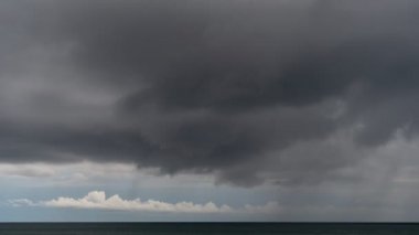 Fırtına bulutlarının ve denizin üzerindeki yağmurun zaman çizelgesi. Karanlık fırtına bulutları video hızını geçiyor.