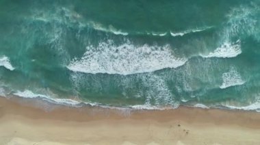 Plajda dalgaların çarptığı tropik deniz. Havadan insansız hava aracı görüntüsü.