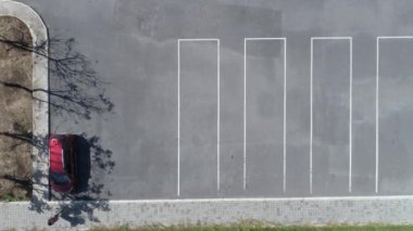 Hava görüntüsü yukarıdan aşağıya İHA görüntüsü. Parktaki boş otoparkın üstünde uçuyor.