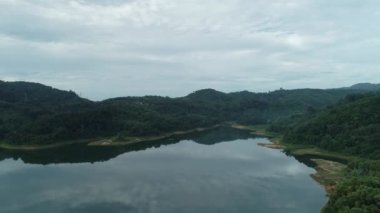 Yağmur ormanlarında dağ sabah havadan kumandalı insansız hava aracı göl üzerinde uçuyor.