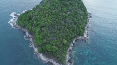 Phuket 'in dağlık güzel manzarasına karşı kayalık kıyısı ve yeşil tepesi olan küçük adanın havadan görüntüsü.