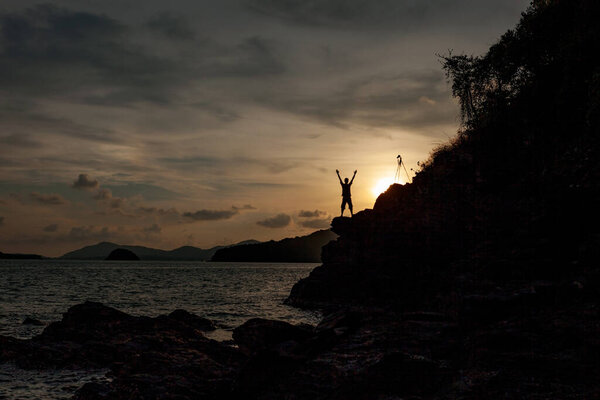 Alone man standing holding his hand up and see landscape scenery view in sunset time