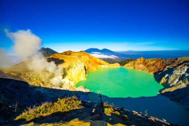 Kawah Ijen volkanındaki kayalık hava manzarası. Güneş doğarken turkuaz sülfür gölü. Endonezya, Doğu Java 'da doğa manzarası. Doğal manzara arka planı