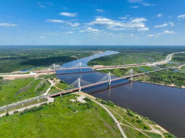 Oka Nehri 'ni kaplayan Murom Köprüsü' nün sudaki yansıması ve yapıya giden bir yol ağı ile insansız hava aracı görüntüsü.