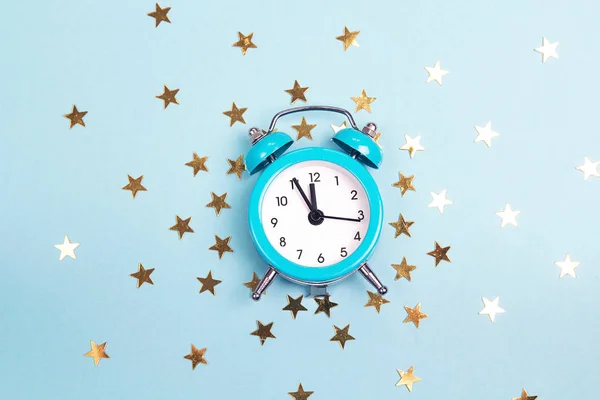 Blue alarm clock with small golden stars. Time for magical events.