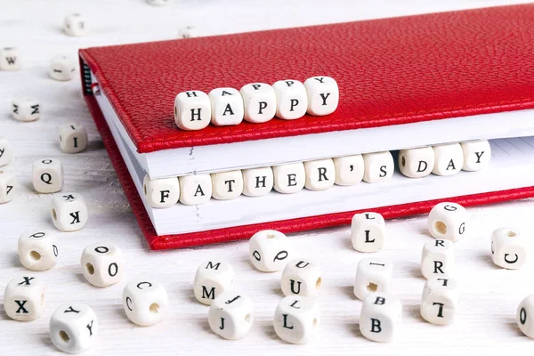 父亲节问候语用红色笔记本上的木块写在白色的木桌上 父亲节背景 — 图库照片