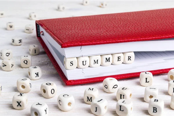 白い木製のテーブルに赤いノートに木製のブロックに書かれた単語夏 Abc — ストック写真
