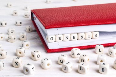 Genesis beyaz tahta masada kırmızı defter ahşap bloklar halinde yazılı kelime. Ahşap abc.