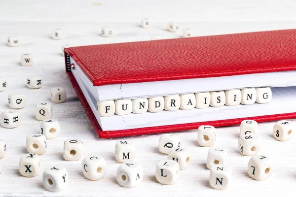 Word Fundraising Napsaný Dřevěných Blocích Červeném Zápisníku Bílém Dřevěném Stole — Stock fotografie