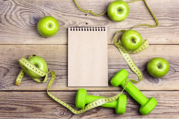 打开空白记事本与绿色哑铃和绿色的苹果与测量磁带和复制空间在旧的木质背景 健身和饮食观念 顶部视图 — 图库照片