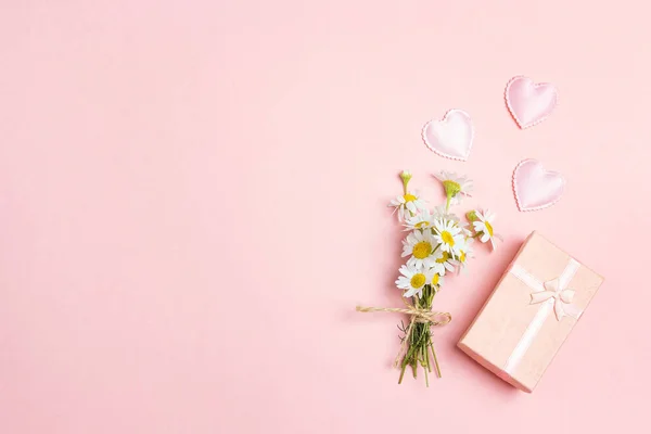 一小束 Chamomiles 与礼品盒和心在粉红色的背景 复制空间 顶部视图 — 图库照片