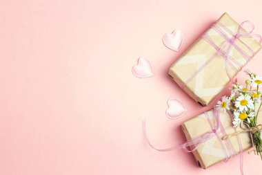 Chamomiles pembe bir arka plan üzerinde hediye kutusu ile küçük bir grup. Uzay kopyalayın. Üstten görünüm.