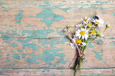 Chamomiles eski ahşap arka plan üzerinde kopya alanı ile küçük buket. Düz yatıyordu, en iyi görünümü.