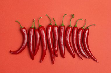 Kırmızı bir arka plan üzerinde kırmızı biber biber. Yukarıdan görüntülemek.