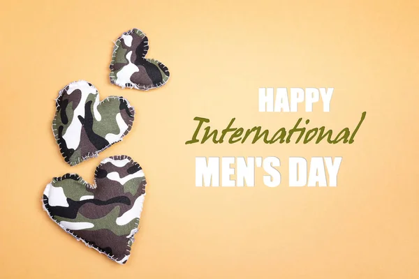 International men\'s day background with military hearts on yellow backdrop.