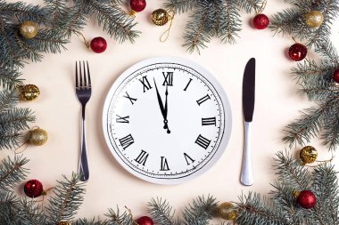 Bıçak ve çatal ve Noel süsleri bej masada saat plaka. Noel tablo ayarı. Yukarıdan aşağıya kompozisyon.