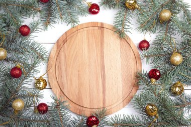 Boş yuvarlak ahşap kesme tahtası çam dalları ve beyaz masada Noel dekorasyonu ile. Yukarıdan aşağıya kompozisyon kopya alanı ile. 