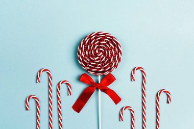 Dekoratif Noel lolipop ve şeker köpekler üzerinde mavi bir arka plan. Düz yatıyordu tepeden kompozisyon.